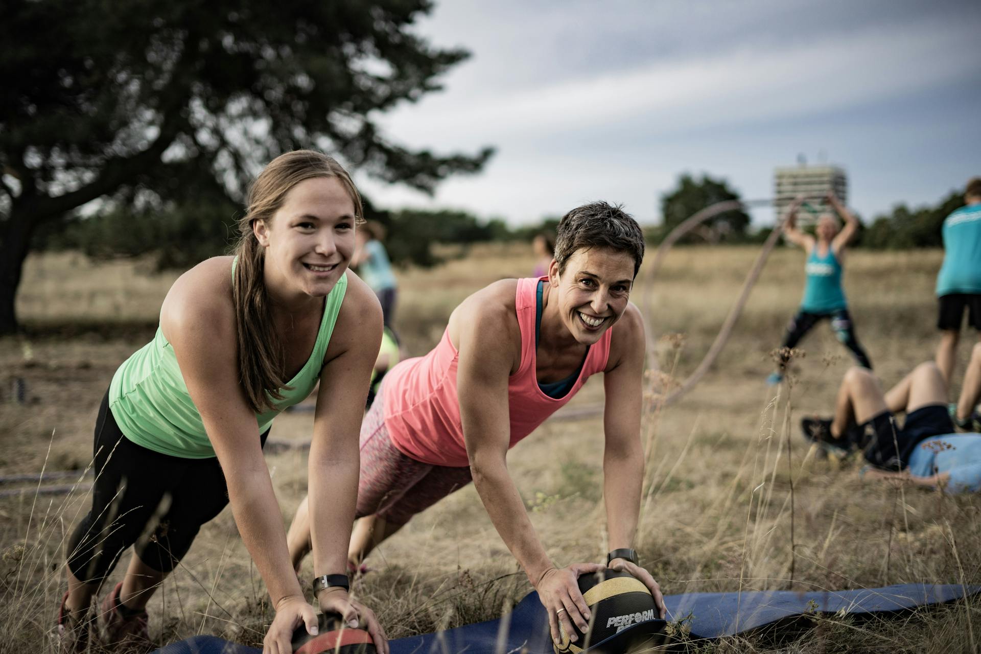 Frauen beim Training mit Medizinbällen beim bootcamp outdoor fitness training